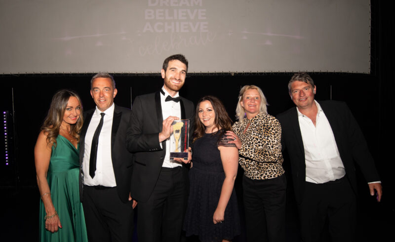 a group of formally dressed people from Gowercroft Joinery posing with an industry award