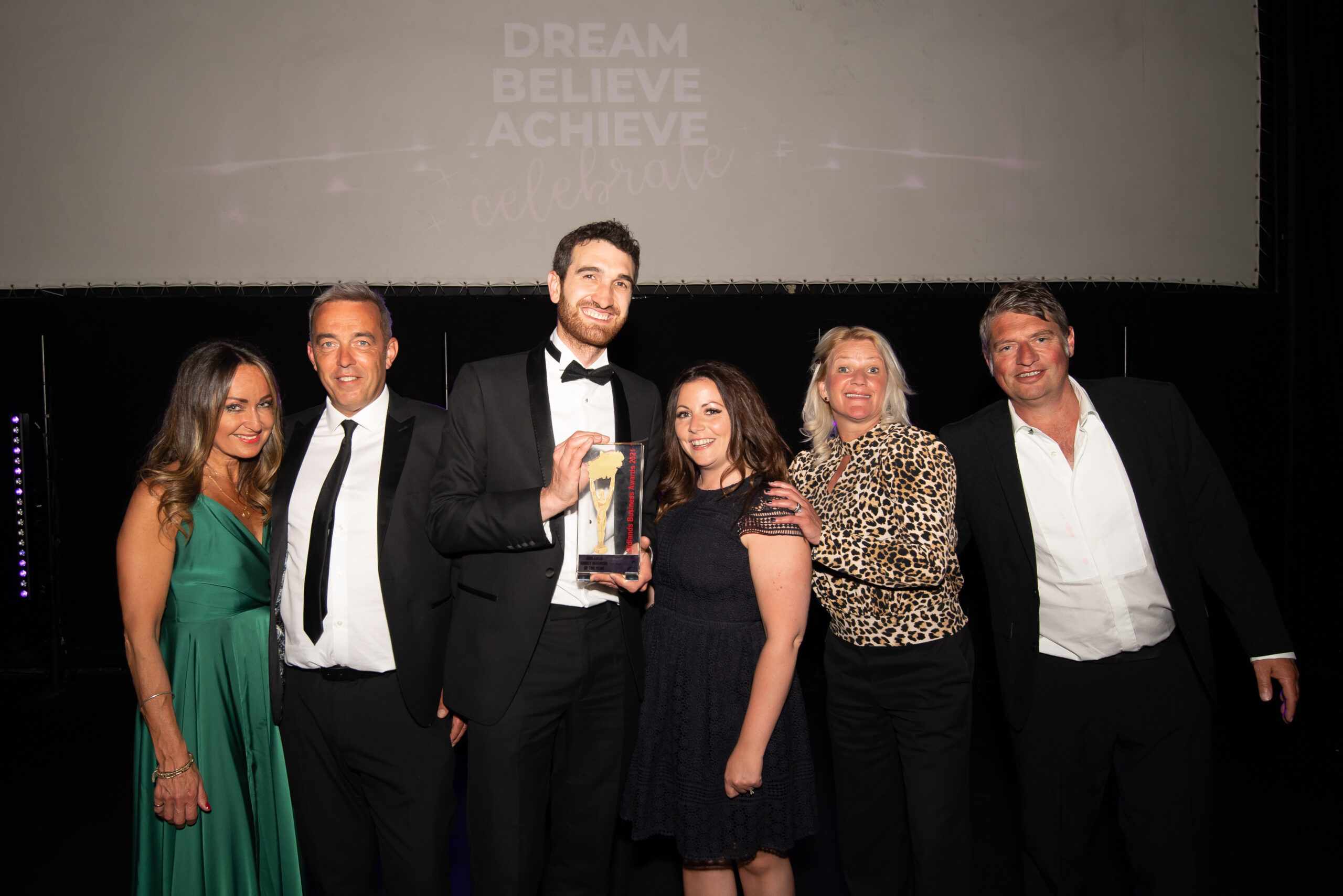 a group of formally dressed people from Gowercroft Joinery posing with an industry award