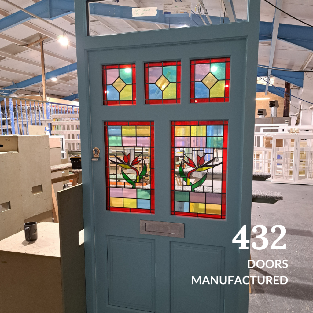 A vibrant stained glass door displayed in the Gowercroft workshop, representing 432 doors manufactured in 2024.